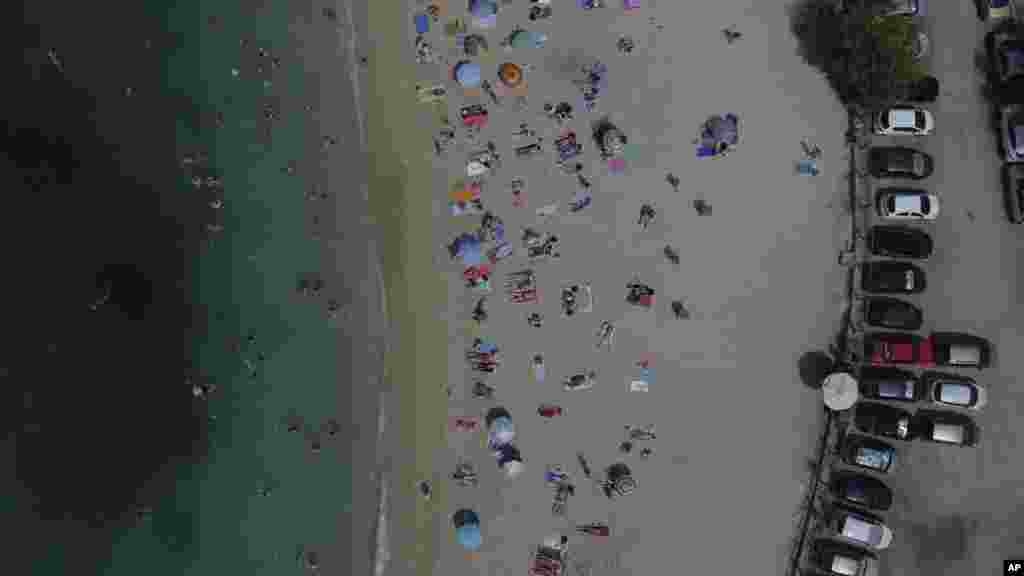 People gather at the public beach of Alimos, in southern Athens, Greece.