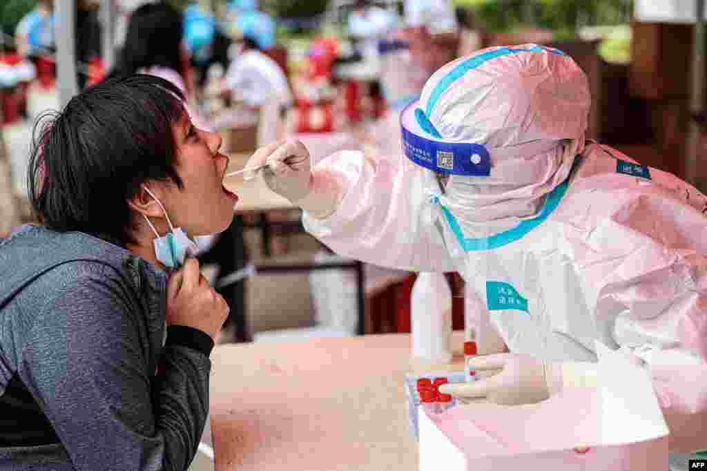 A health worker takes a swab sample from a resident to test for the COVID-19 coronavirus in Shenyang, in northeastern China's Liaoning province.