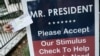 ARCHIVO - Un trabajador de Florida se apostó el 29 de mayo de 2020 frente a la Casa Blanca para devolver su cheque de estímulo económico y que fuera reenviado a otros necesitados.