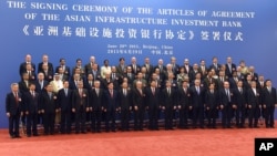 中国国家主席习近平(右九)在北京人民大会堂与参加亚洲基础设施投资银行创始成员国签字仪式的各国代表合影。（2015年6月29日）