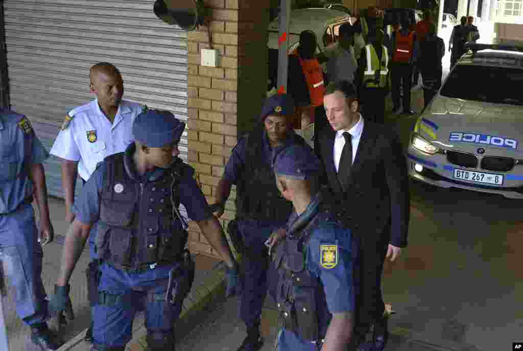 Oscar Pistorius is led to a awaiting police vehicle to be taken to prison, in Pretoria, South Africa, Oct. 21, 2014.