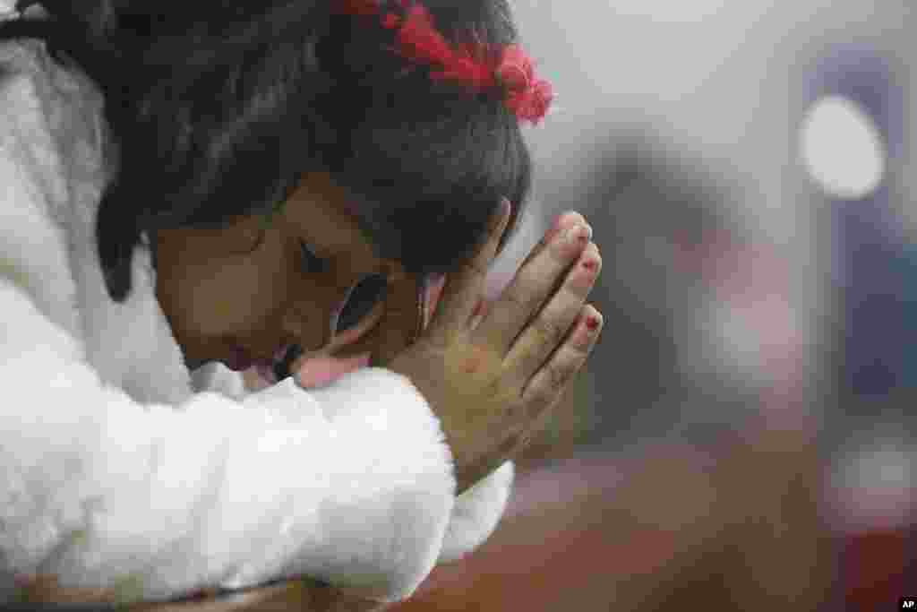 An Indian girl prays during the midnight Christmas Mass at Saint Joseph's Cathedral in Lucknow, India, Dec. 25, 2017.