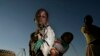 FILE - A young girl carries her sister through a cornfield in Masongo village outside Lilongwe, Malawi, May 13, 2008. 