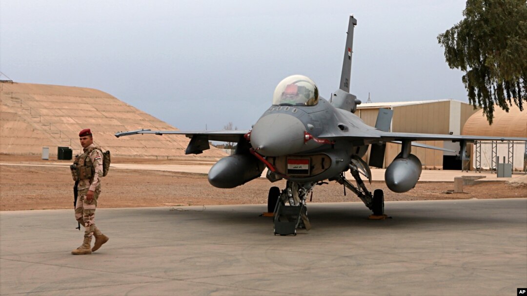 FILE - An Iraqi soldier stands guard near a U.S.-made Iraqi air force F-16 jet at Balad Air Base, north of Baghdad, Iraq, Feb. 13, 2018.