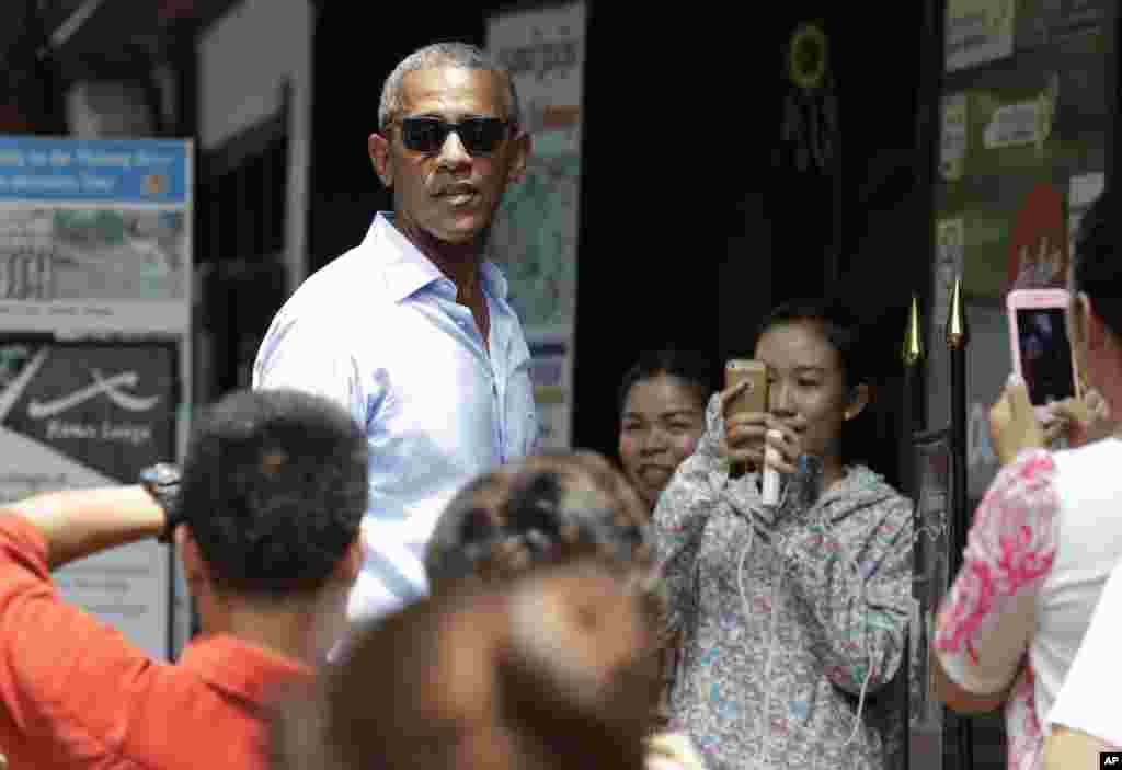 Warga lokal mengambil foto Presiden AS Barack Obama saat ia mengunjungi daerah perbelanjaan dekat Sungai Mekong di Luang Prabang (7/9). (AP/Carolyn Kaster)