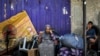 Seorang perempuan dan anak menunggu dengan barang-barangnya sebelum dievakuasi dari Rafah di Jalur Gaza selatan pada 11 Mei 2024, di tengah konflik di wilayah Palestina antara Israel dan Hamas. (Foto: AFP)