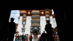 Chinese tourists pose for a picture while showing "v" signs at the Potala palace in Lhasa