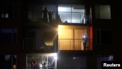 ARCHIVO - Personas bailan en un balcón en Bogotá durante el confinamiento por el COVID-19. Abril 22, 2020.