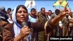 Dayikeke Kurd di mersîma binaxkirina kurê xwe de deng dike. Kobanê, Tîrmeh, 2014