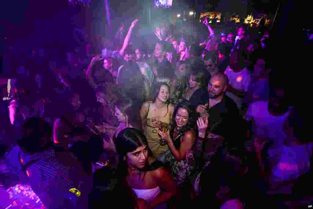 People drink on the dance floor shortly after the reopening at The Piano Works in Farringdon, in London. Thousands of young people plan to dance the night away at 'Freedom Day' parties when almost all coronavirus restrictions in England are to be scrapped.