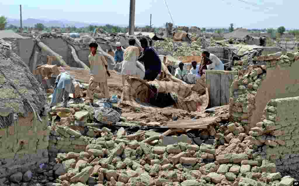Villagers look for belongings amid the rubble of their destroyed homes following an earthquake in the remote district of Awaran, Baluchistan province, Pakistan, Sept. 25, 2013. 
