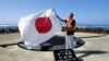 日本东京都知事石原慎太郎在冲之鸟展示日本国旗（2005年5月20日）