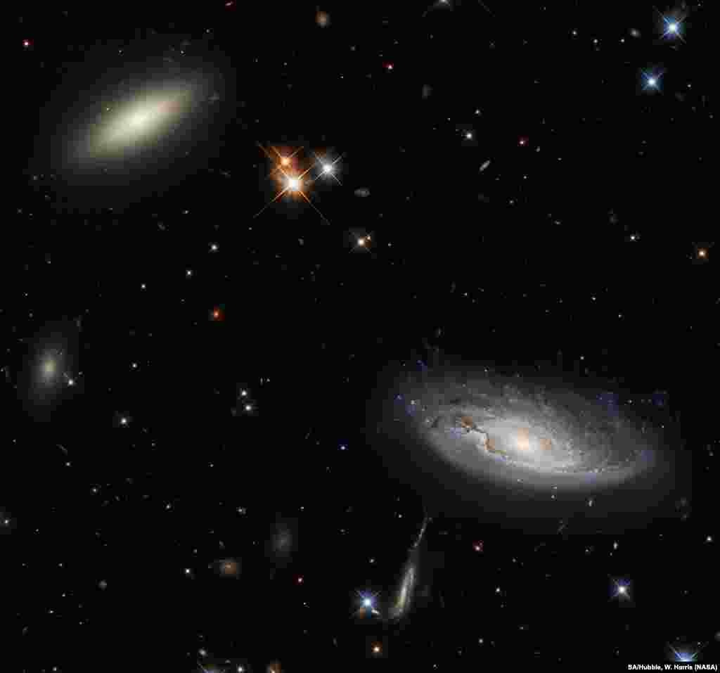 A lenticular galaxy, L, and the spiral galaxy named UGC 2665, R, lie approximately 350 million light-years from Earth. They both form part of the enormous Perseus galaxy cluster.