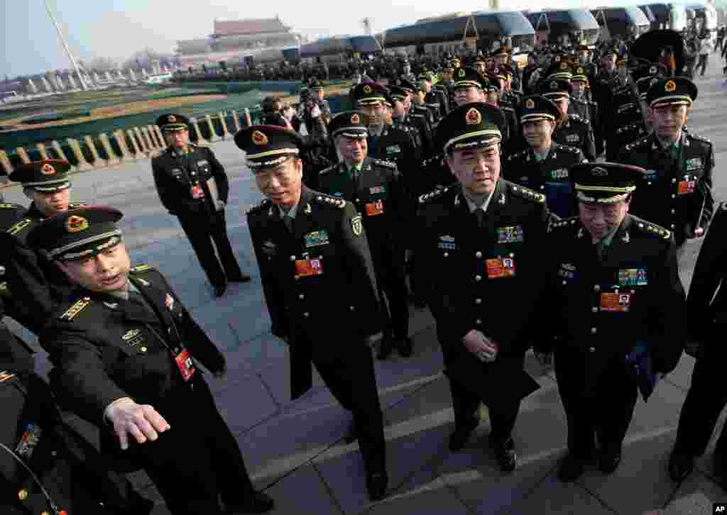 Delegasi-delegasi dari Tentara Pembebasan Rakyat China berbaris di Alun-Alun Tiananmen sambil bersiap memasuki gedung tempat Kongres Nasional Rakyat China diadakan (5/3). (AP/Andy Wong)