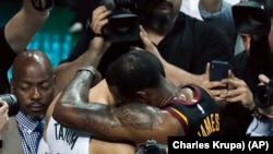 Košarkaš Klivlend Lebron Džejms grli rukija Bostona Džejsona Tejtuma na kraju sedme utakmcie finala Istočne konferencije u Bostonu, 27. maja 2018. (Foto: AP/Charles Krupa))