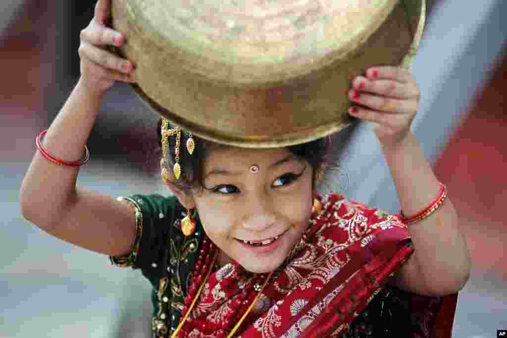 Seorang anak perempuan dengan pakaian tradisional menunggu festival keagamaan 'Kumari puja' di sebuah candi di Kathmandu, Nepal.