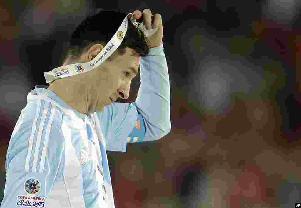Lionel Messi yana cire tasa lambar azurfa da aka ba 'yan wasan kasar Argentina, bayan da suka zo na biyu a gasar Copa America. 'Yan Chile suka doke su suka dauki kofin da kuma lambar zinare.