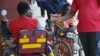 Conforzi Biliati recieves money from an alms giver in the street of Blantyre. Government says it wants to ban street begging.