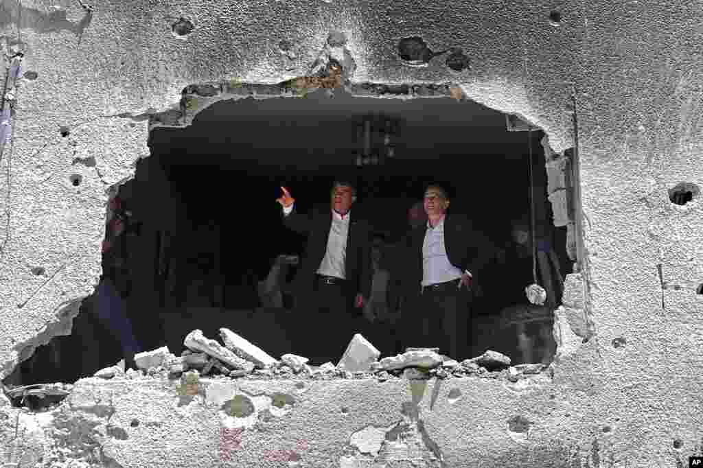 German Foreign Minister Heiko Maas, right, and Israeli Foreign Minister Gabi Ashkenazi visit the site of a rocket attack in the central Israeli city of Petah Tikvah.