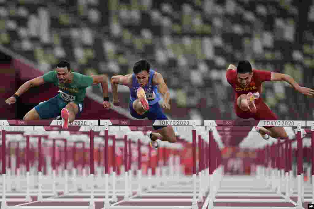 Rafael Pereira, left, of Brazil, Kuei-Ru Chen, of Taiwan, and Wenjun Xie,right, of China, compete in a heat of the men's 110-meter hurdles at the 2020 Summer Olympics, in Tokyo, Japan.