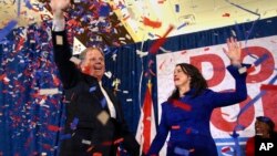 Dorgomaa paartii Demokriaati Doug Jones fi niitii Louise-tti dorgommii Senetii Alabaamaa moohannana akkana gammachuun harka raasa..Muddee 12, 2017, Birmingham, Ala.