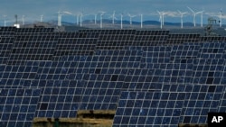 FILE - Solar panels and windmills work near the small town of Milagro, Navarra Province, northern Spain, Feb. 24, 2023. (AP Photo/Alvaro Barrientos, File)