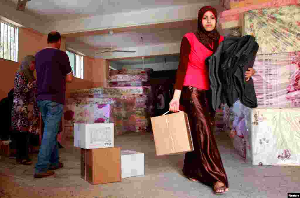 Seorang pengungsi menerima selimut dan bahan bantuan lain dari Palang Merah Internasional (ICRC) di kamp Baddawi sebelah selatan Lebanon. (Reuters/Omar Ibrahim)