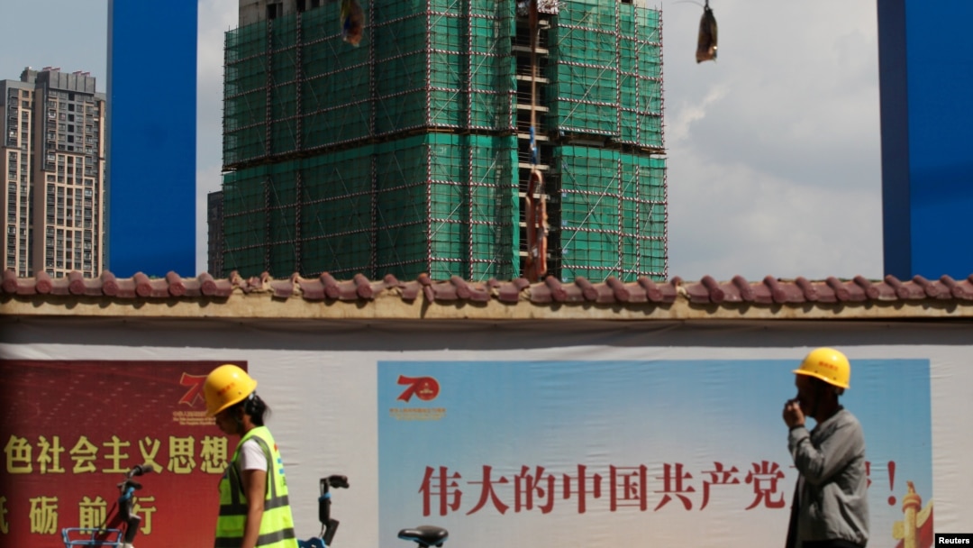 中國工人從雲南省昆明市一處建築工地旁走過。（2019年9月17日）