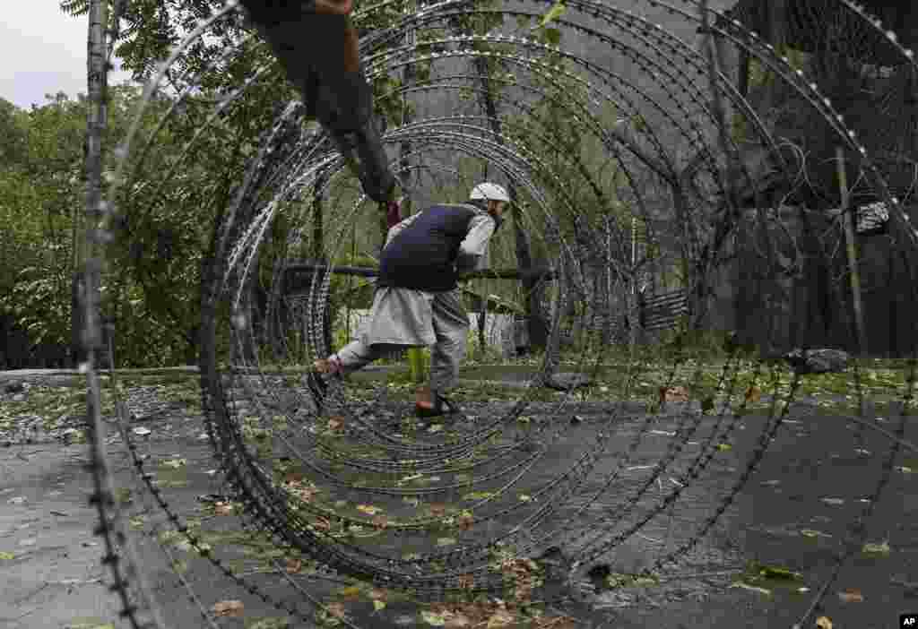 Seorang pria Kashmir berusaha melewati barikade di dekat pangkalan militer India di Braripora, Kashmir.