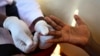 FILE - A doctor draws blood to check for HIV/AIDS at a mobile testing unit in a suburb of Uganda’s capital, Kampala.