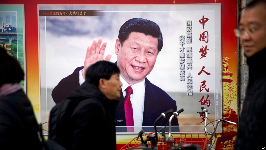 資料照片:北京街頭人們走過一個有著習近平肖像,並寫著“中國夢,人民的夢”的廣告看板。 (2018年3月2日)