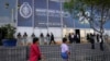 ARCHIVO - Los peatones pasan frente a la fiscalía donde la presidenta peruana Dina Boluarte llegó para testificar, en Lima, Perú, el viernes 5 de abril de 2024.