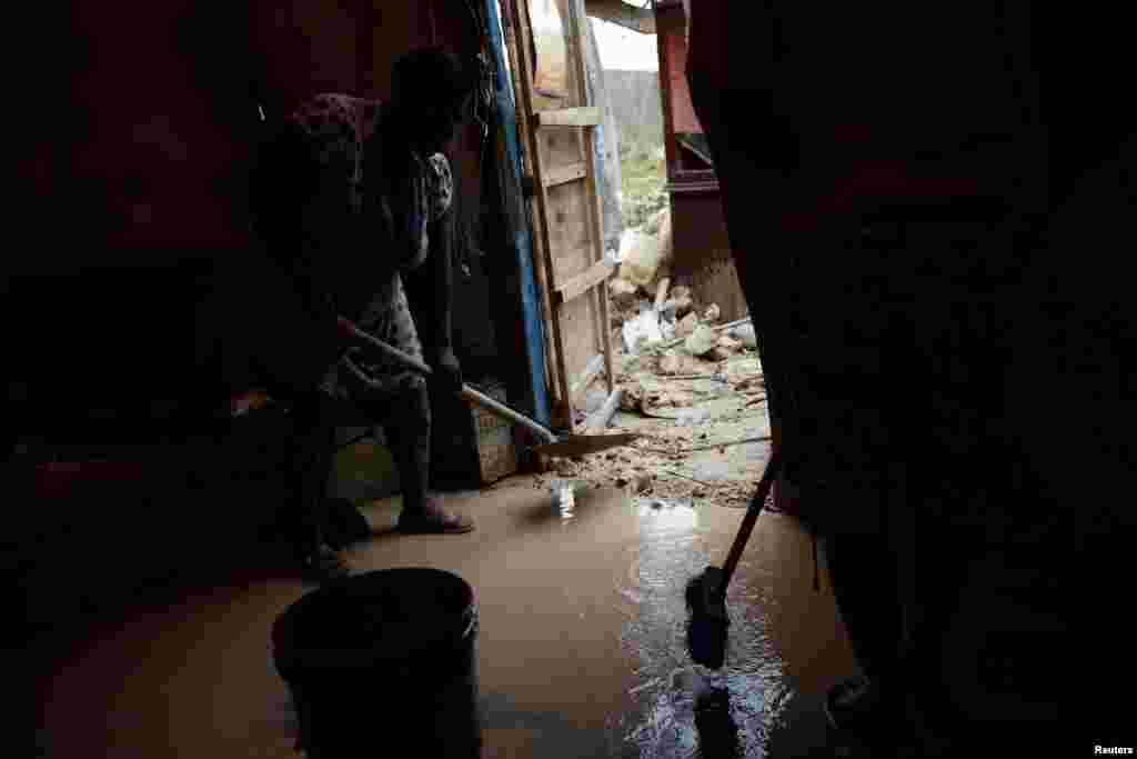 Warga di Jeremie, Haiti, membersihkan lumpur di rumah mereka yang hancur akibat Badai Matthew (6/10). (Reuters/Carlos Garcia Rawlins)