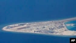菲律宾空军一架运输机在南中国海南沙群岛的中国制造的人造岛礁渚碧礁上空飞越时拍摄的照片，显示人造岛礁上的简易机场和建筑物。（2017年4月21日）