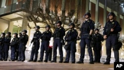 FILE - In this Feb. 1, 2017, photo, University of California, Berkeley police guard the building where Breitbart News editor Milo Yiannopoulos was to speak in Berkeley.