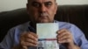 Fuad Sharef Suleman shows his US immigrant visa in Arbil, the capital of the Kurdish autonomous region in northern Iraq, Jan. 30, 2017, after returning to Iraq from Egypt, where him and his family were prevented from boarding a plane to the U.S. following President Donald Trump's decision to temporarily bar travelers from seven countries, including Iraq.