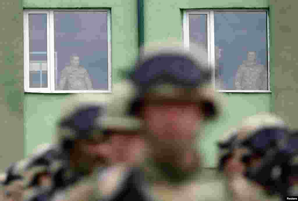 Tentara Georgia melihat keluar dari jendela dalam upacara resmi menjelang latihan militer bersama Georgia-AS di pangkalan militer Vaziani di luar Tbilisi, Georgia.