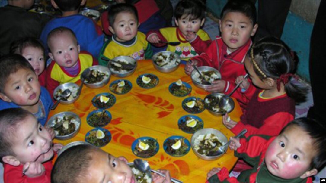 In this photo released by the World Food Program, North Korean children eat a lunch, including rice provided by the U.N. World Food Program.