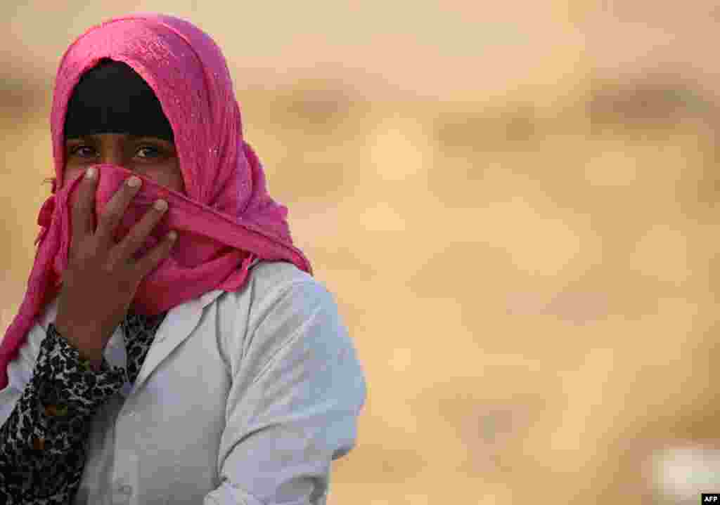A young girl smiles at a refugee camp housing Iraqi families who fled fighting in the Mosul area in the northeastern town of al-Hol in Syria's Hasakeh province.