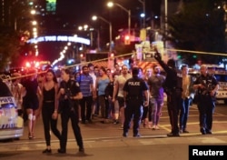 People leave an area cordoned off by police near the scene of a shooting incident in Toronto, Canada, July 22, 2018.