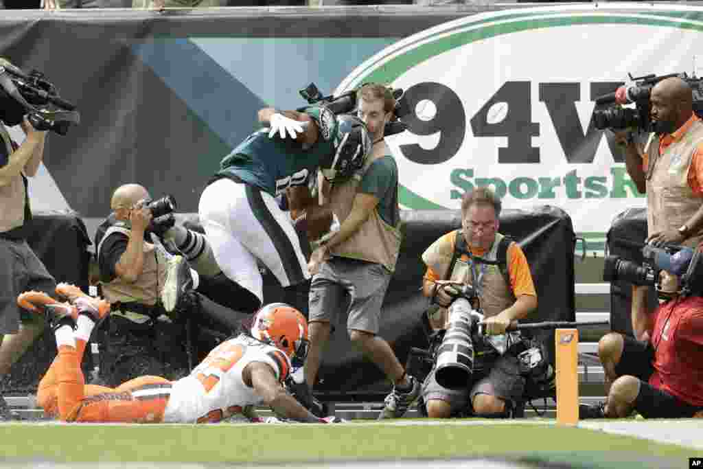 Philadelphia Eagles' Jordan Matthews crashes into a television photographer after catching a touchdown pass against Cleveland Browns' Tramon Williams during the first half of an NFL football game in Philadelphia, Pennsylvania.