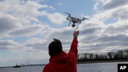 Drone operator Parker Gyokeres helps to retrieve a drone after photographing over Hart Island in New York, April 29, 2018.