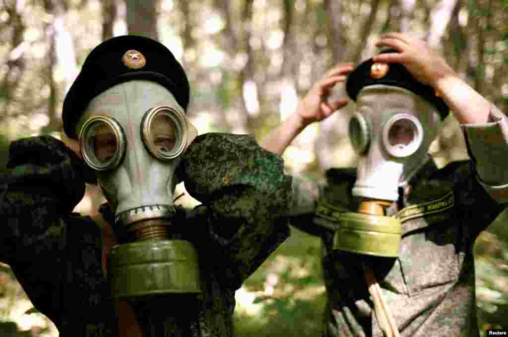 Anak-anak SD di Stavropol, Rusia belajar mengenakan topeng gas pada latihan militer pertama mereka. 