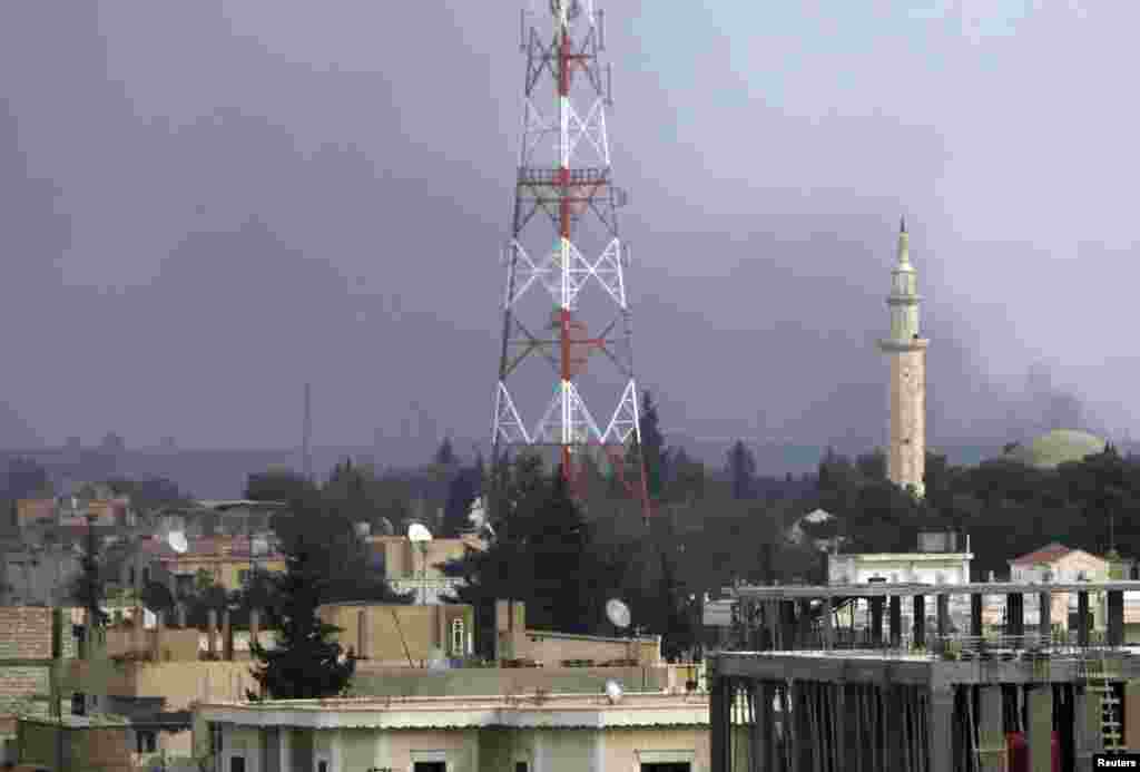 Smoke rises over the Syrian town of Ras al-Ain as gunfire is heard, as seen from the Turkish border town of Ceylanpinar, Sanliurfa province, November 22, 2012.