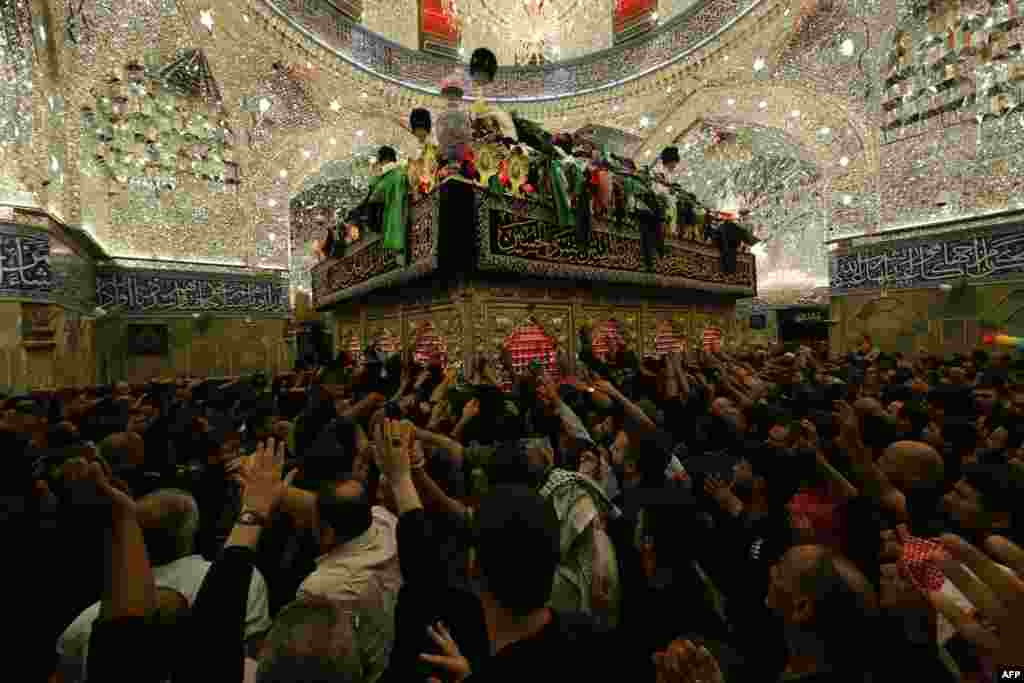 Muslim-Syiah Irak berdoa di dalam masjid Imam Abbas pada malam 10 Muharram, yang menandai hari Asyura (Ashoura) di kota suci Karbala, Irak.