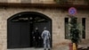 A private security guard speaks with a policeman at the residence of former Nissan chairman Carlos Ghosn, in Beirut, Lebanon, Dec. 31, 2019.