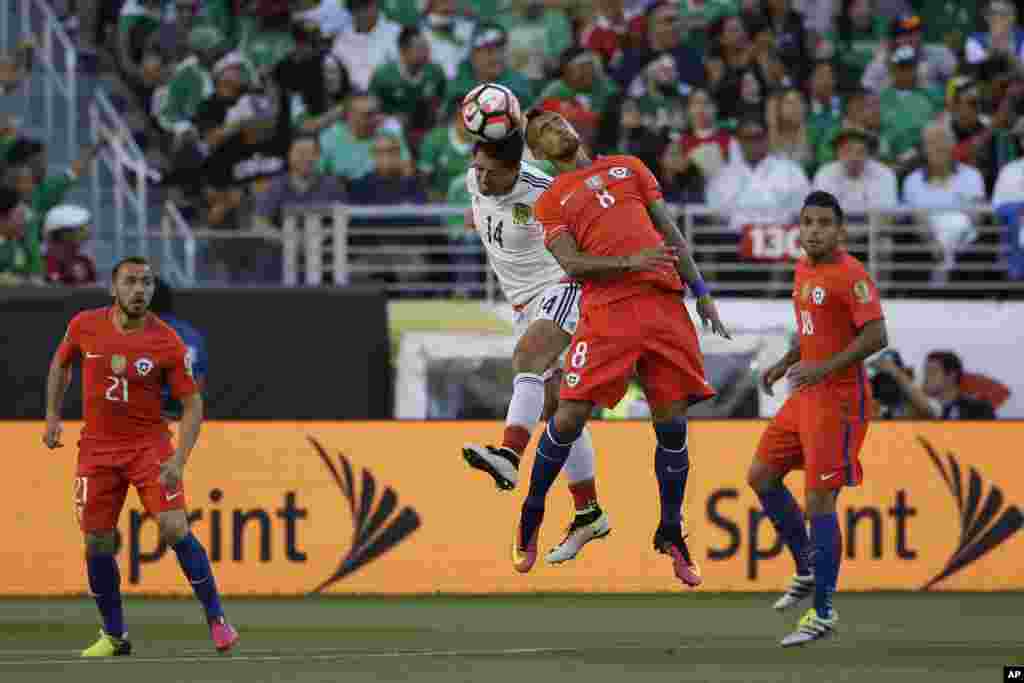  Dan wasan Mexico, Javier Hernandez, na biyu daga hagu da Arturo Vidal na kasar Chile (mai sanye da riga mai lamba 8) su na kokawar neman kwallo a lokacin karawar tasu.