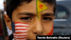 Zarokekî Kurd rûyê xwe bi alên Amerîka, YPG û Kurdistanê reng kiriye