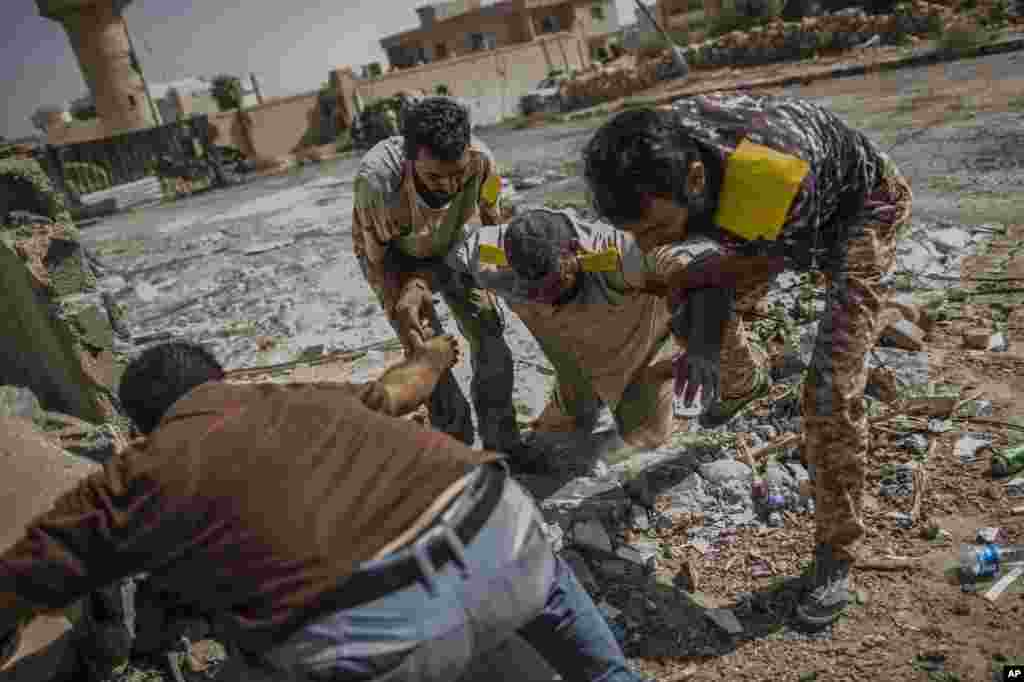 Seorang anggota tentara Libya ditolong oleh rekannya setelah terkena tembakan sniper (penembak tersembunyi) di Sirte, Libya.