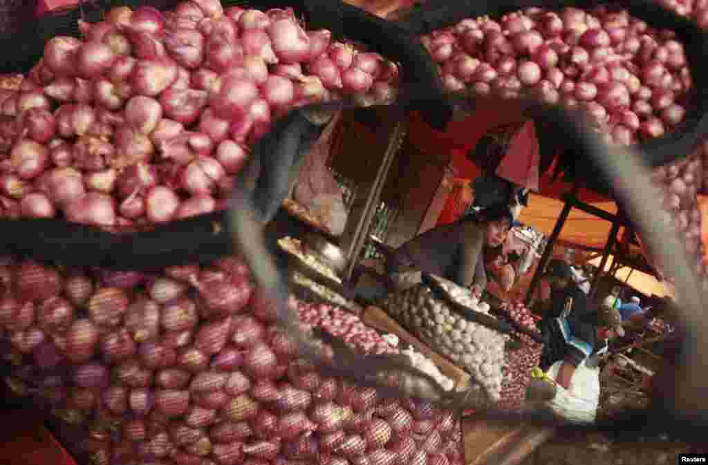 Seorang penjual bawang merah, terlihat dari kaca spion, menunggu pelanggan di sebuah pasar di kota Makassar, Sulawesi Selatan. Inflasi di Indonesia melonjak ke level tertinggi dalam dua tahun pada bulan Maret, akibat kelangkaan bawang putih dan bawang merah.
